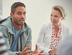 late 30's man sitting near older woman in group setting