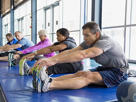 group of men and women doing stretching exercises